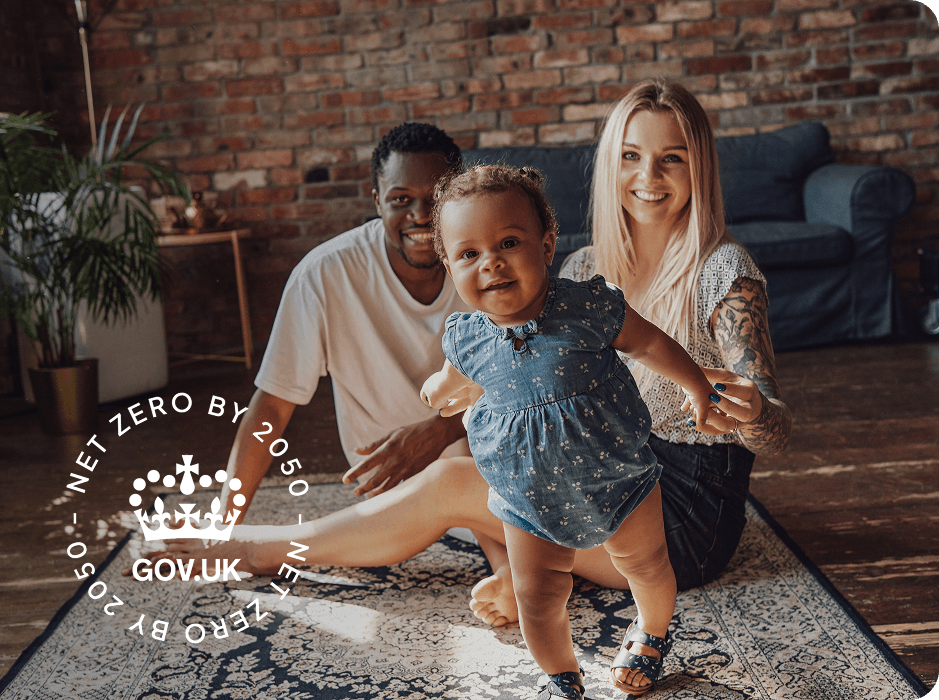 A family photo of a mother, father and baby in a warm home